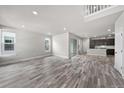 Open-concept living room with wood floors, leading to the kitchen with modern appliances at 8894 Yellowcress St, Littleton, CO 80125