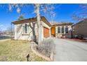 Charming stucco home featuring a wooden garage door and arched windows for a lovely curb appeal at 13901 E Saratoga Pl, Aurora, CO 80015