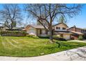 Well-maintained two-story home featuring a lush green lawn and mature trees in a suburban setting at 7590 E Easter Pl, Centennial, CO 80112