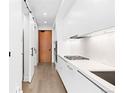 Sleek modern kitchen with white cabinets and stainless steel appliances with wood floors at 1901 Wazee St # 304, Denver, CO 80202