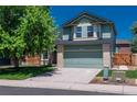 Two-story home featuring a front-facing two car garage, mature landscaping, and a brick facade at 20445 Mitchell Pl, Denver, CO 80249