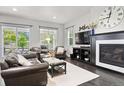 Cozy living room with plush seating, fireplace, and large windows offering natural light and a view of the outdoors at 1867 W 137Th Ln, Broomfield, CO 80023