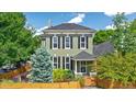 Charming two-story home with black shutters, a manicured front yard, and a privacy fence at 2098 N Clarkson St, Denver, CO 80205