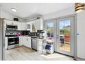 Modern kitchen with stainless steel appliances and ample natural light from the door to the deck at 3902 S Uravan St, Aurora, CO 80013