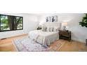 Comfortable bedroom features hardwood floors, a large window, neutral decor, and soft natural light at 7308 S Steele Cir, Centennial, CO 80122