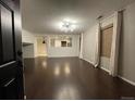 Spacious living room featuring dark hardwood floors and a view into the kitchen at 269 Ponderosa Pl, Fort Lupton, CO 80621