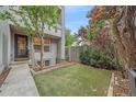 A modern townhome showcasing a backyard with manicured artificial turf and mature trees for added privacy at 1655 N Williams St, Denver, CO 80218