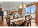 Open dining room with a chandelier, kitchen access, and sliding door to backyard at 20826 Robins Dr, Denver, CO 80249