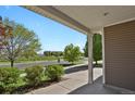 Covered porch with white columns offers scenic neighborhood views and manicured landscaping at 20826 Robins Dr, Denver, CO 80249