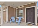 Cozy covered porch with two blue chairs, perfect for relaxing outdoors at 20826 Robins Dr, Denver, CO 80249