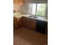 Traditional kitchen with double sink, tile floor, and backyard view at 482 S Kalispell Way # E, Aurora, CO 80017