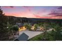 An aerial view of a house with a large driveway, a spacious front yard, and scenic mountain views at 12555 Critchell Ln, Littleton, CO 80127