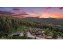 Elevated view of a grand estate nestled in the mountains, showcasing beautiful landscaping and natural surroundings at 12555 Critchell Ln, Littleton, CO 80127