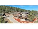 Gorgeous home featuring a large driveway, stone accents, a basketball court, and lush landscaping for outdoor enjoyment at 12555 Critchell Ln, Littleton, CO 80127