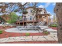 Multi-story home with stone accents, wooden decks, and a backyard patio, perfect for outdoor entertaining at 12555 Critchell Ln, Littleton, CO 80127