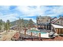 Inviting backyard with a refreshing pool, hot tub, outdoor seating, and lovely views of the surrounding wooded landscape at 12555 Critchell Ln, Littleton, CO 80127