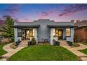 Charming bungalow with inviting front porch and well-manicured lawn at dusk at 3764 N Raleigh St, Denver, CO 80212
