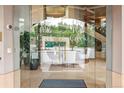 Elegant condo entrance features glass doors with the building name and a view of the grand lobby at 2400 E Cherry Creek South Dr # 207, Denver, CO 80209