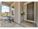 Inviting covered porch with seating and stylish front door entrance at 4884 St Vrain Rd, Firestone, CO 80504