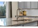 Close-up of kitchen island featuring granite countertop and modern faucet at 4884 St Vrain Rd, Firestone, CO 80504