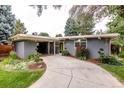Well-maintained single-story home showcasing a curved driveway, lush lawn, and mature landscaping at 1338 S Fairfax St, Denver, CO 80222