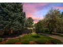 Dusk shot of well-maintained single-story home featuring a landscaped front yard and elegant exterior lighting at 1338 S Fairfax St, Denver, CO 80222