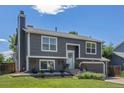 A gray two-story home with an attached garage and landscaped front yard at 3965 S Fundy Cir, Aurora, CO 80013