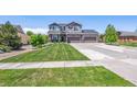 Two-story house with a landscaped yard, driveway, and attached garage at 8939 Devinney Ct, Arvada, CO 80005