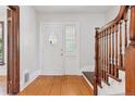 Inviting entryway featuring hardwood floors, a decorative front door, and elegant wooden banister at 1352 N Downing St, Denver, CO 80218