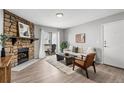 Bright living room with stone fireplace, wood floors, balcony access, and stylish modern furniture at 13333 E Asbury Dr # 104, Aurora, CO 80014