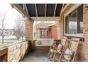 Inviting covered front porch with swing and rocking chairs, perfect for relaxing at 3370 W Clyde Pl, Denver, CO 80211