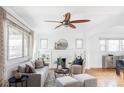 Bright living room featuring hardwood floors, a decorative fireplace, and natural light at 3370 W Clyde Pl, Denver, CO 80211