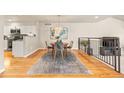 Charming dining area adjacent to the kitchen features wood floors and modern chandelier at 2609 S Quebec St # 9, Denver, CO 80231