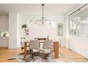 Bright dining room with a wooden table, stylish chairs, and a unique modern chandelier at 3929 Newton St, Denver, CO 80211