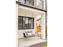 Charming porch swing with decorative pillows, complemented by a side table and greenery at 3929 Newton St, Denver, CO 80211