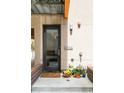 Inviting front entrance with a modern door, brick accents, and colorful flowers, adding curb appeal at 1945 W 34Th Ave, Denver, CO 80211