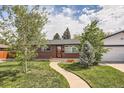 Charming brick home featuring a well-manicured lawn, inviting walkway, and mature trees at 2986 W Union Ave, Englewood, CO 80110