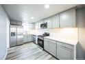 Modern kitchen with stainless steel appliances, light gray cabinets, and tile backsplash at 901 S Osceola St, Denver, CO 80219