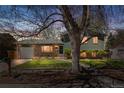 Charming home at twilight featuring a well-maintained front yard, brick accents, and mature tree at 845 S Kenton St, Aurora, CO 80012