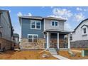Inviting two-story home with stone accents, charming porch, and well-maintained front yard at 691 N Tempe St, Aurora, CO 80018