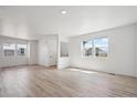 Spacious living room with abundant natural light, freshly painted, and wood-look flooring at 691 N Tempe St, Aurora, CO 80018