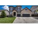 Stunning two-story home featuring stone accents, a three-car garage, and professionally landscaped front yard at 6738 Esmeralda Dr, Castle Rock, CO 80108