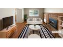 Bright living room with hardwood floors, a brick fireplace, and modern furniture at 13235 Rigel Dr, Lone Tree, CO 80124