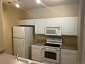 Efficient kitchen with white appliances, ample white cabinetry, and light countertops at 5255 Memphis St # 712, Denver, CO 80239