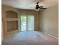 Neutral living room with a ceiling fan, a sliding glass door to a balcony, and a decorative alcove at 5255 Memphis St # 712, Denver, CO 80239