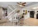 Dining area with modern chairs and a view of the stairway and kitchen with black appliances and neutral-toned cabinets at 12430 E Pacific Cir # B, Aurora, CO 80014