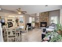 Spacious living area featuring a stone fireplace, adjacent dining area, and an open layout connecting to the modern kitchen at 12430 E Pacific Cir # B, Aurora, CO 80014