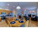 Open living space with a kitchen island, dining table, and cozy fireplace at 10132 Nickolas Ave, Highlands Ranch, CO 80130