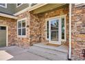 Charming front entrance with a glass door, stone accents, and a welcoming porch, enhancing curb appeal at 282 N De Gaulle St, Aurora, CO 80018