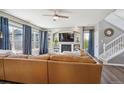 Comfortable living room with hardwood floors, large windows with curtains, fireplace with built-ins, and a spacious sectional at 282 N De Gaulle St, Aurora, CO 80018